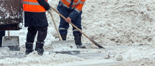 Communal services workers sweep snow from road in winter, Cleaning city streets and roads during snowstorm. Moscow, Russia