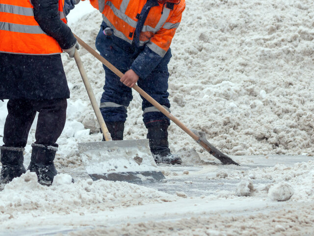 Communal services workers sweep snow from road in winter, Cleaning city streets and roads during snowstorm. Moscow, Russia