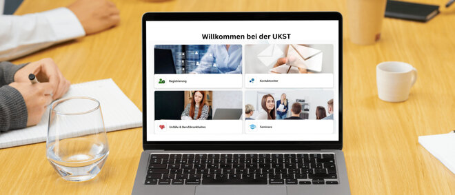 Ein geöffneter Laptop auf einem Konferenztisch, der Bildschirm zeigt die Startseite des Portals MeineUKST