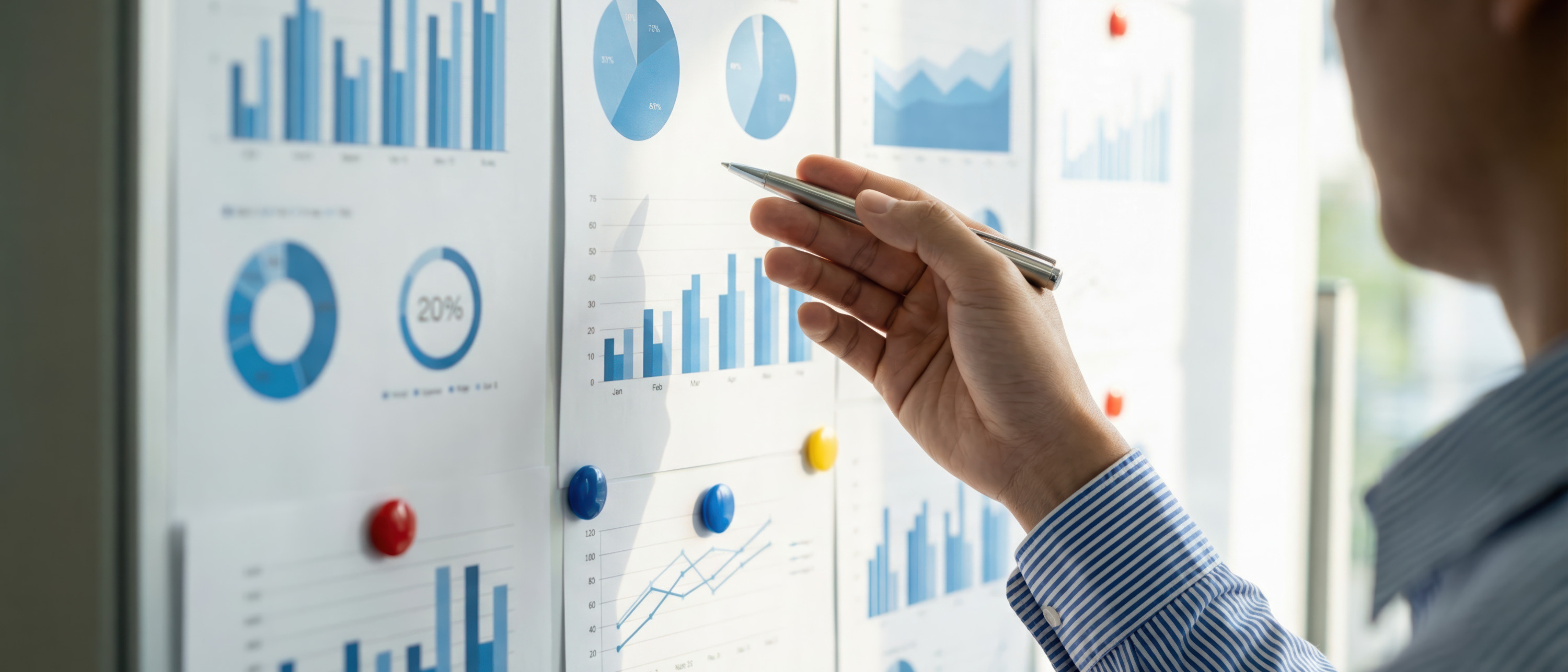 Close up of a businessman in action pointing at a statistic chart during a team data analysis meeting. 