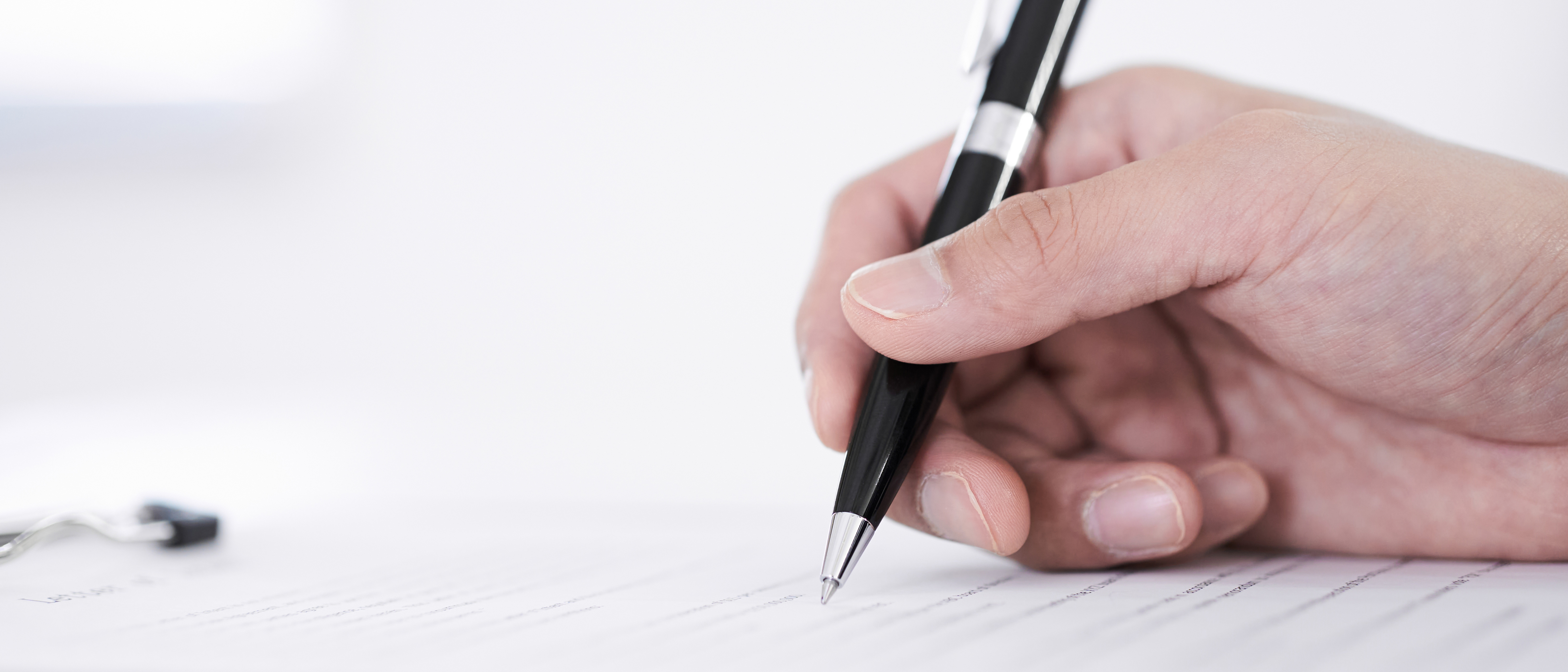 Hand mit Stift auf Papier