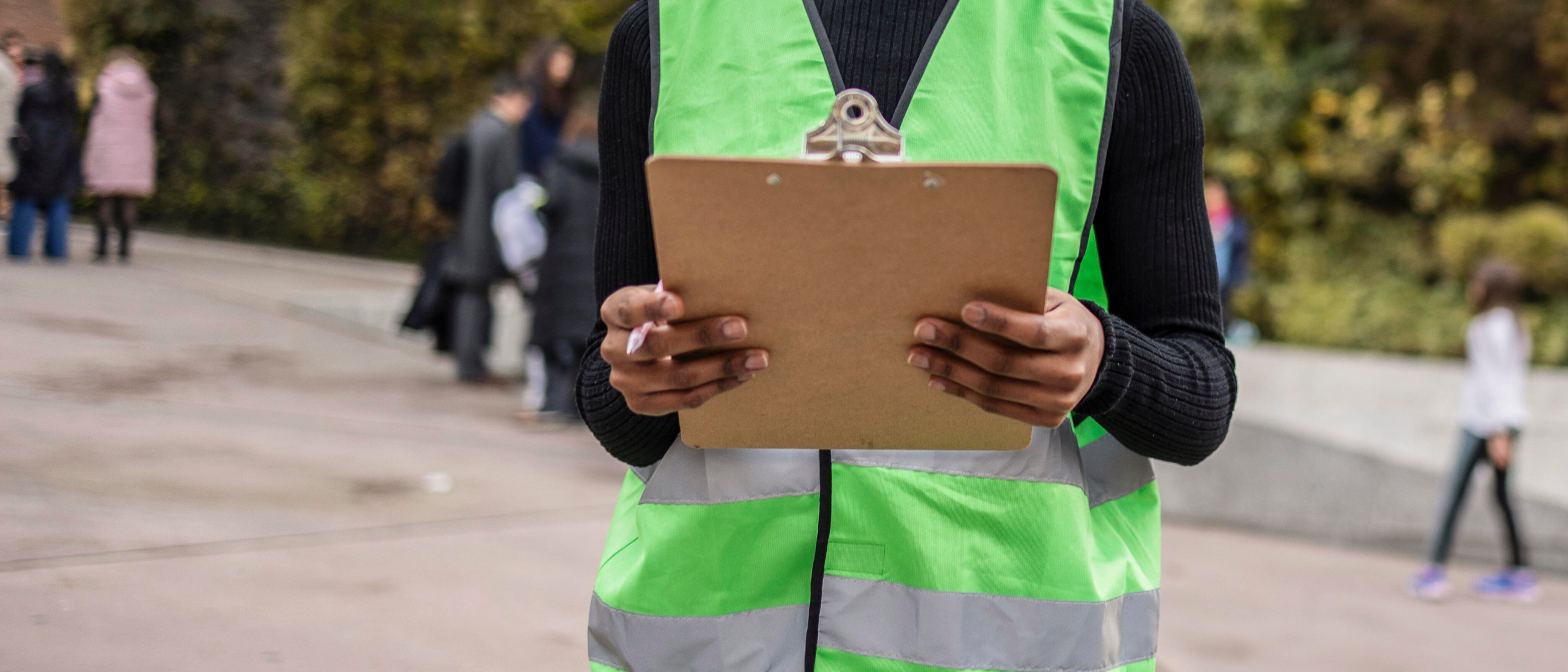 Volunteer with clipboard campaigning outdoors in urban area